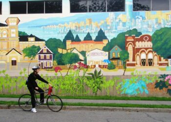 artists painting mural at university campus