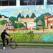 artists painting mural at university campus