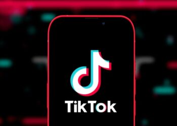 TikTok logo on smartphone with US flag background