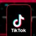 TikTok logo on smartphone with US flag background
